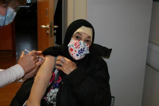 Aicha Chamchoun sat in a doctor's surgery chair receiving her Covid-19 jab